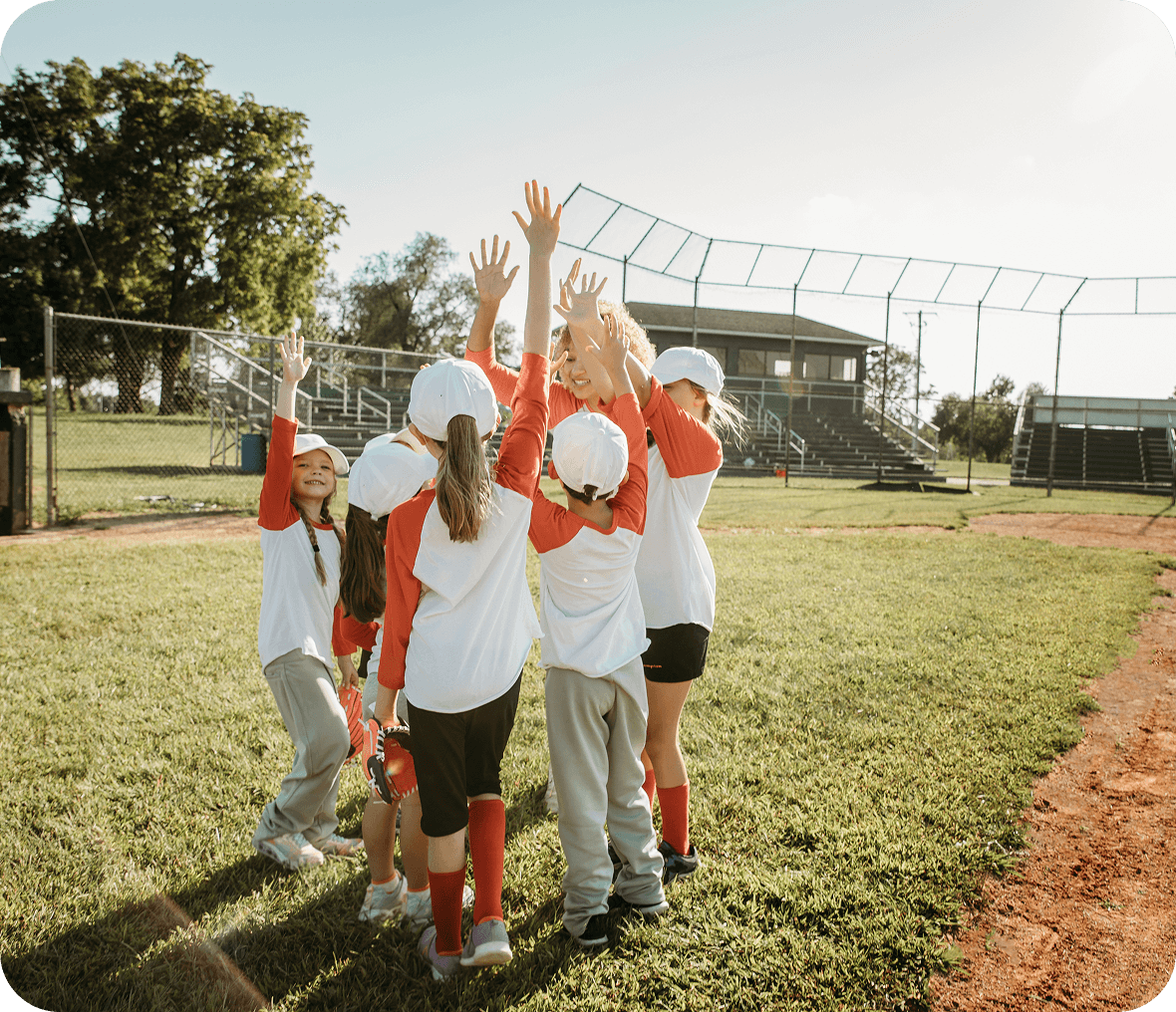 Children celebrating on a baseball field.