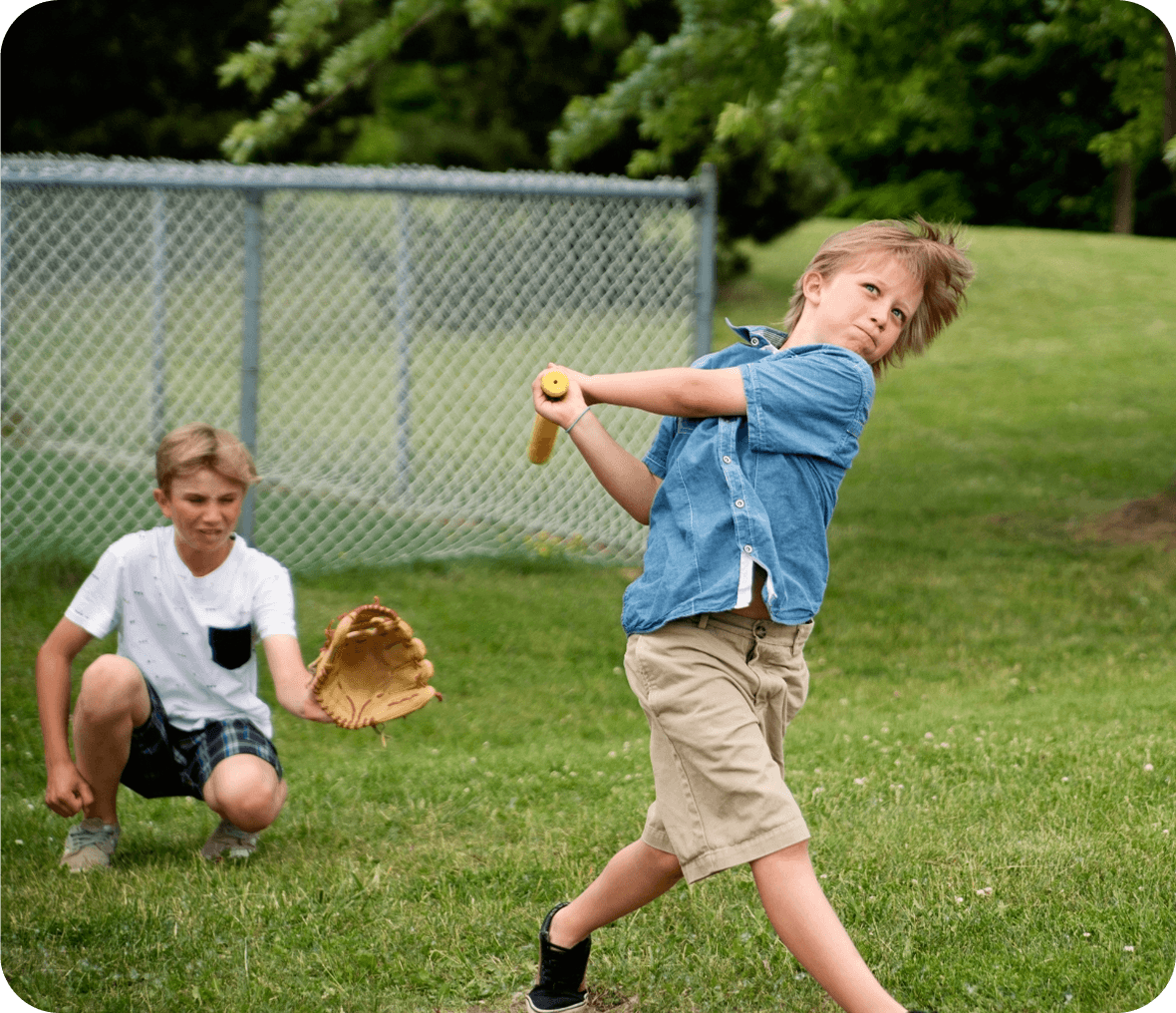 Kids playing baseball on grassy field.